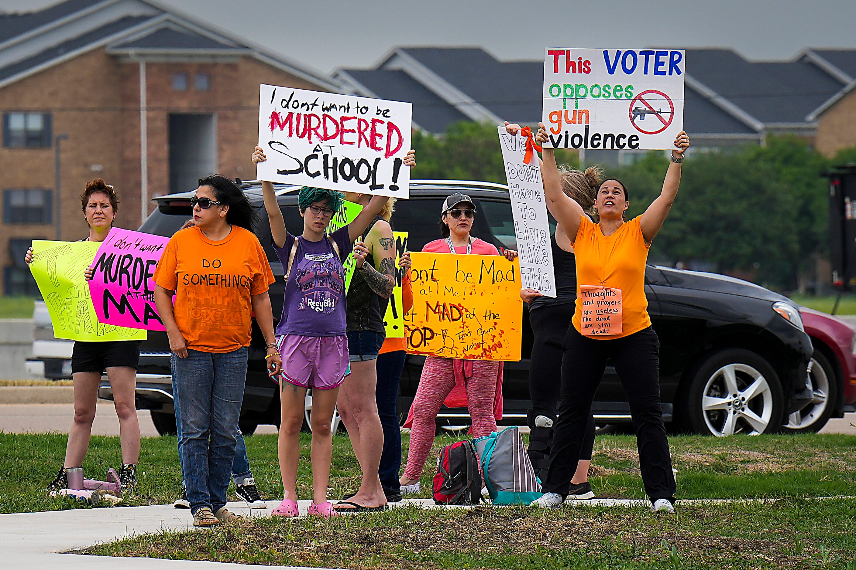 A group of protestors hold signs in support of gun control outside Cottonwood Creek Church...