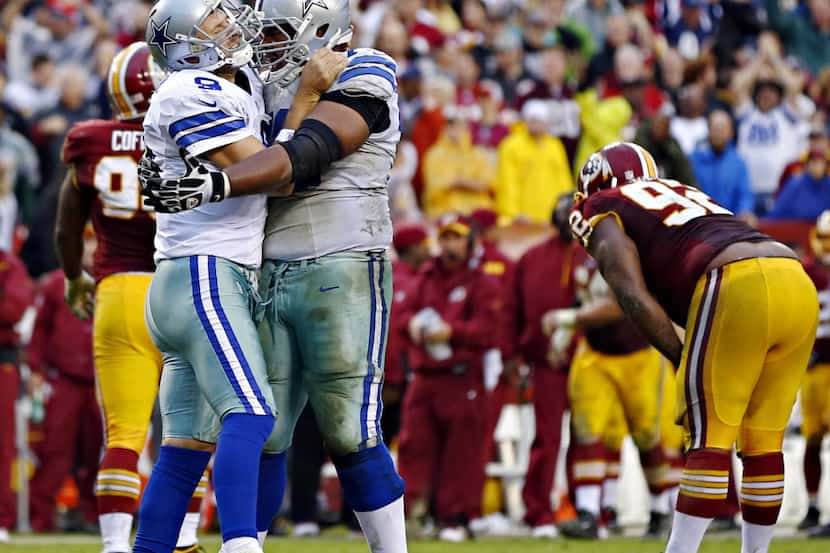 Dallas Cowboys quarterback Tony Romo (9) embraces guard Mackenzy Bernadeau after a...