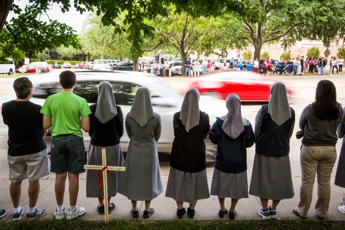 Abortion opponents line the sidewalk in prayer as traffic passes on Greenville Avenue during...