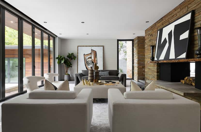 A living room looks out to floor-to-ceiling windows that are clean and bright.