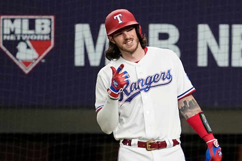 Texas Rangers' Jonah Heim gives a thumbs up after teammate Adolis Garcia hit a two-run home...