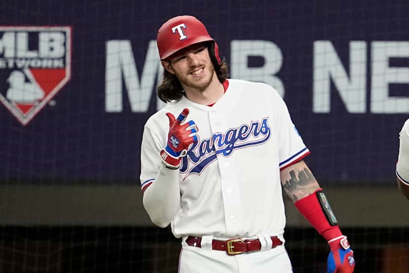 Texas Rangers' Jonah Heim gives a thumbs up after teammate Adolis Garcia hit a two-run home...