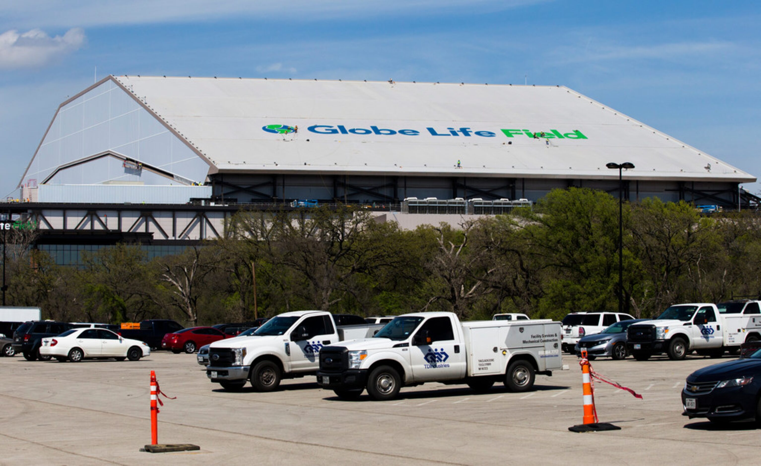 Crews work on a Globe Life Field logo on the roof of the stadium during an open house for...