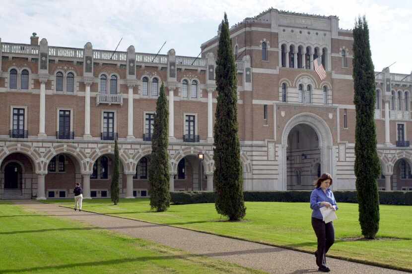 An unidentified woman walks past Rice University's Lovett Hall, the oldest building on...