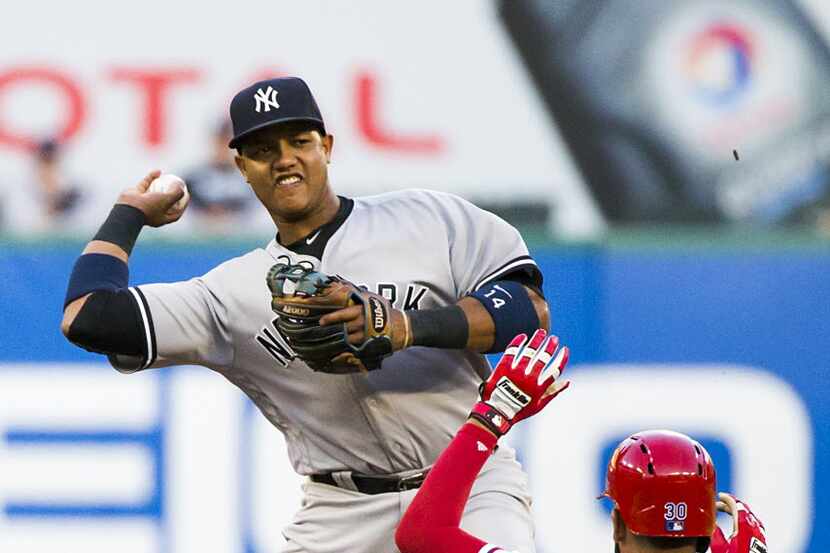 New York Yankees second baseman Starlin Castro makes the relay to try for a double play over...