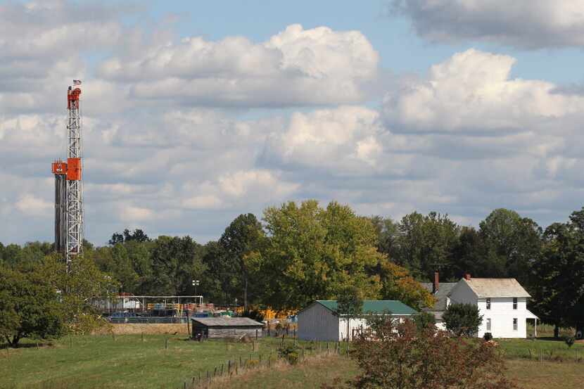 This Sept. 19, 2012, file photo shows a drilling rig across the street from a farmhouse in...