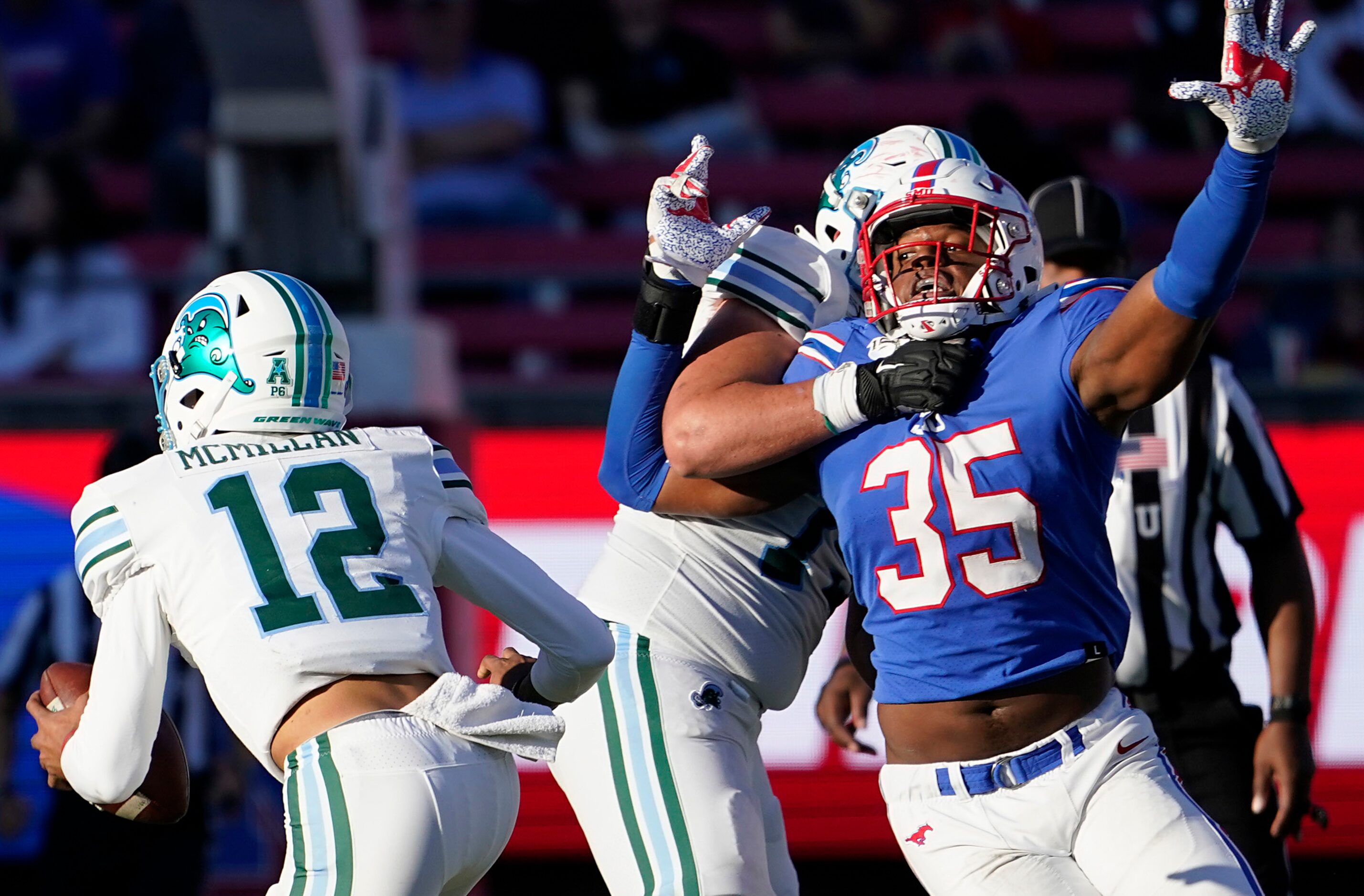 Tulane quarterback Justin McMillan (12) scrambles away from SMU defensive end Delontae Scott...