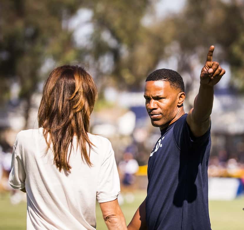 Entertainer Jamie Foxx points to the crowd as he watches a joint practice between the...