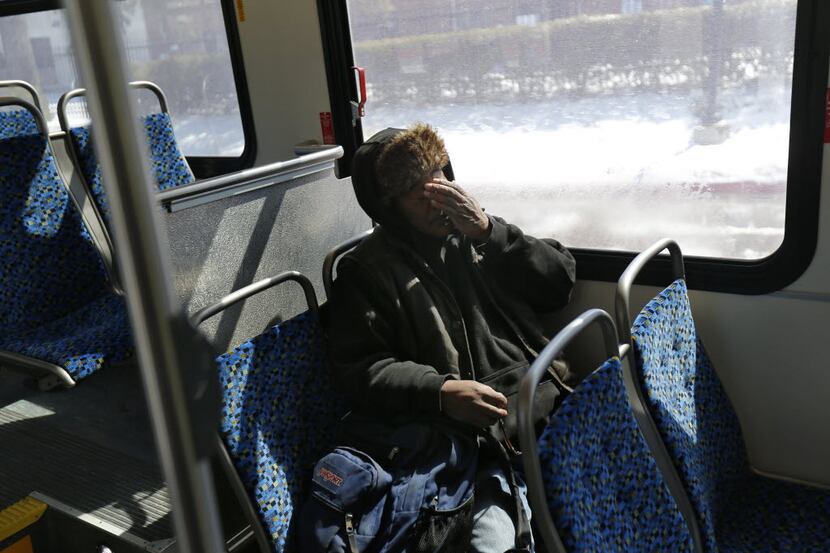 Artis Frank rubs his face during on his last leg of his commute on a DART bus in Dallas...