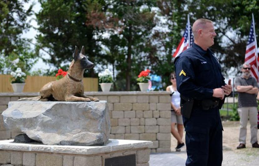 
Cpl. J.R. Podany of the Cedar Hill Police speaks to attendees next to a statue of his...