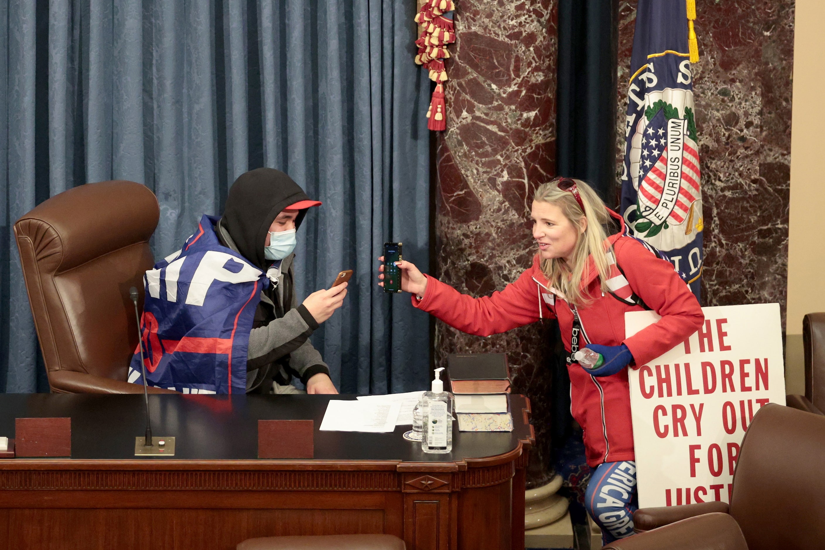 A protester sits in the Senate Chamber on Wednsday, Jan. 6, 2021 in Washington, D.C....