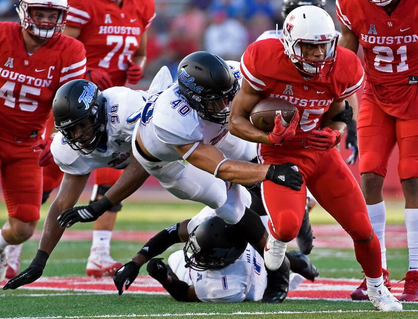 FILE - In this Oct. 15, 2016, file photo, Houston running back Dillon Birden, right, escapes...