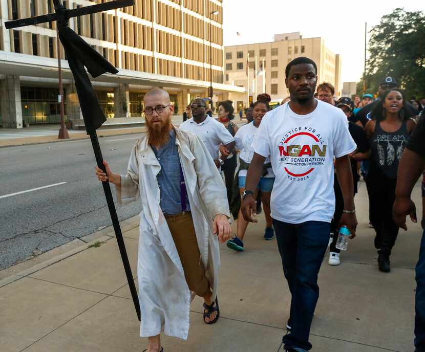 The Rev. Jeff Hood (left) and Dominique Alexander lead protesters east on Commerce Street...