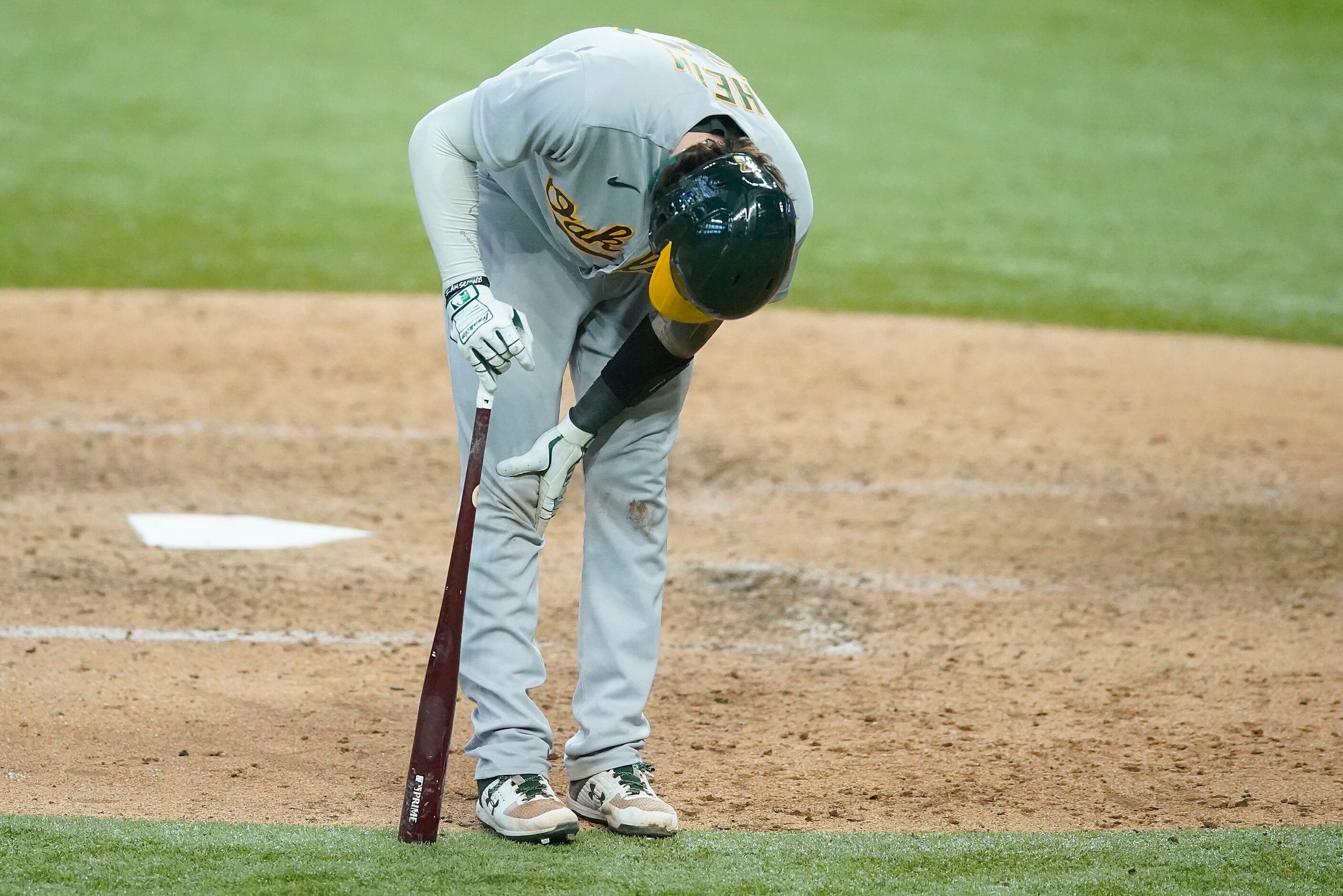 Oakland Athletics catcher Jonah Heim reacts after fouling a ball off his leg during the...