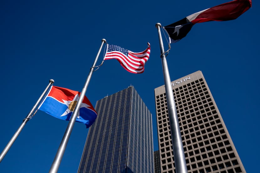 The flags of the City of Dallas, United States and Texas fly in front of Renaissance Tower,...