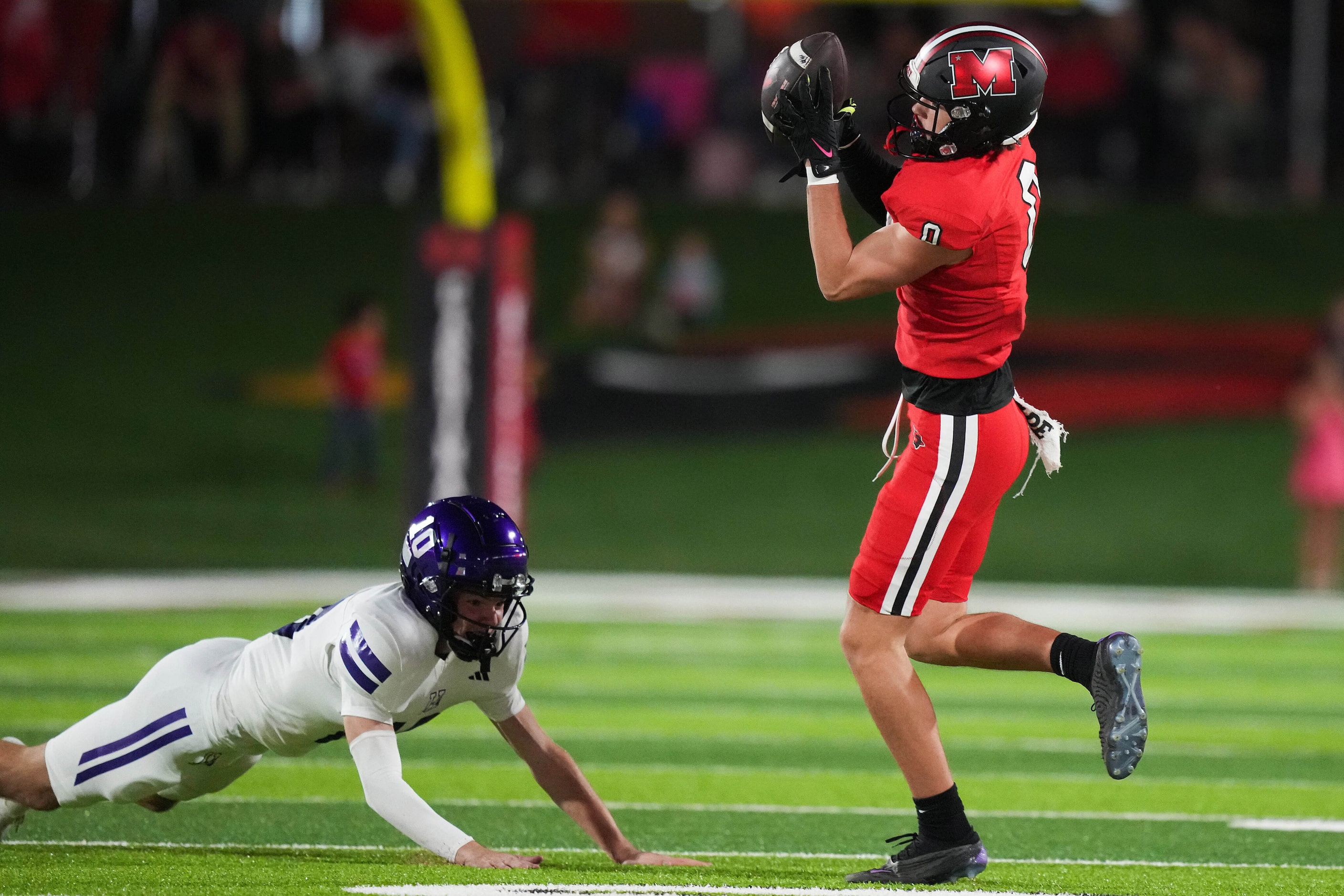 Melissa wide receiver Brett Pool (0) catches a pass behind Anna defensive back Aiden Palmer...