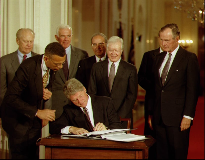 President Bill Clinton signs side deals to the three-nation North American Free Trade...