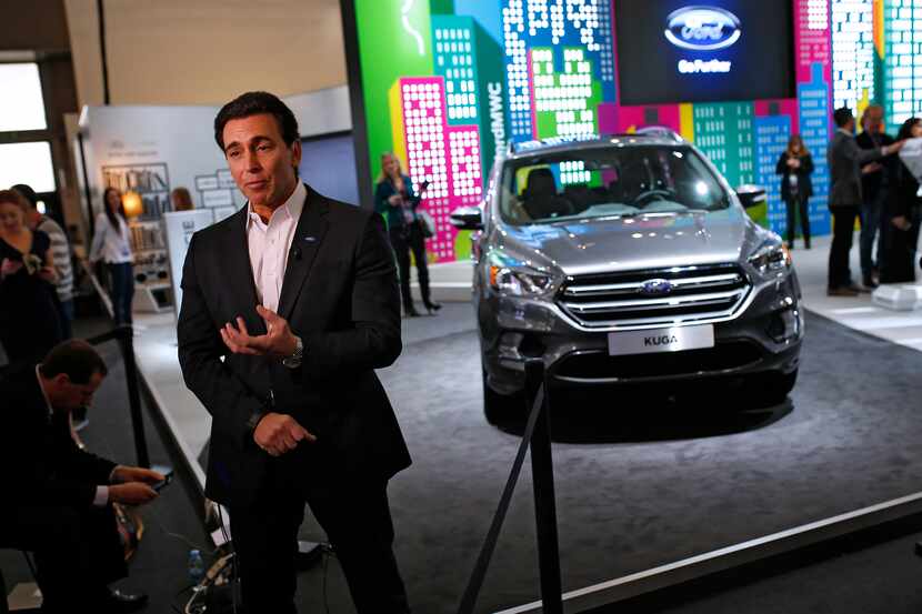 Ford CEO Mark Fields talks during an interview next to the new Kuga SUV car, which features...