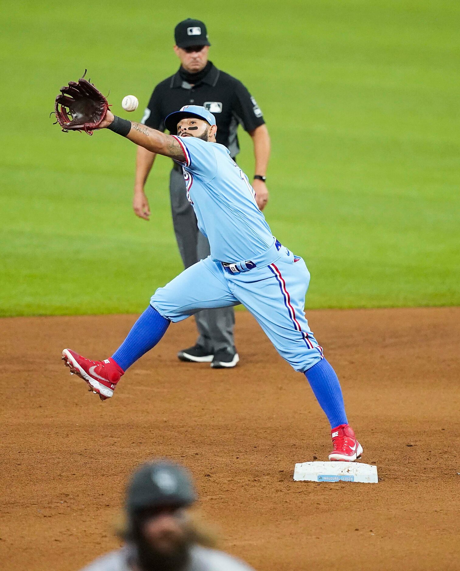 A throwing error by Texas Rangers pitcher Joe Palumbo pulls second baseman Rougned Odor of...