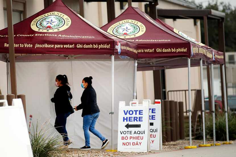 People arrive to the Tarrant County Elections Center to vote early in Fort Worth, Tuesday,...