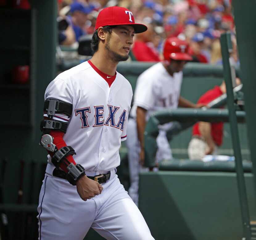Texas Rangers starting pitcher Yu Darvish (11) is pictured in the dugout wearing a brace on...