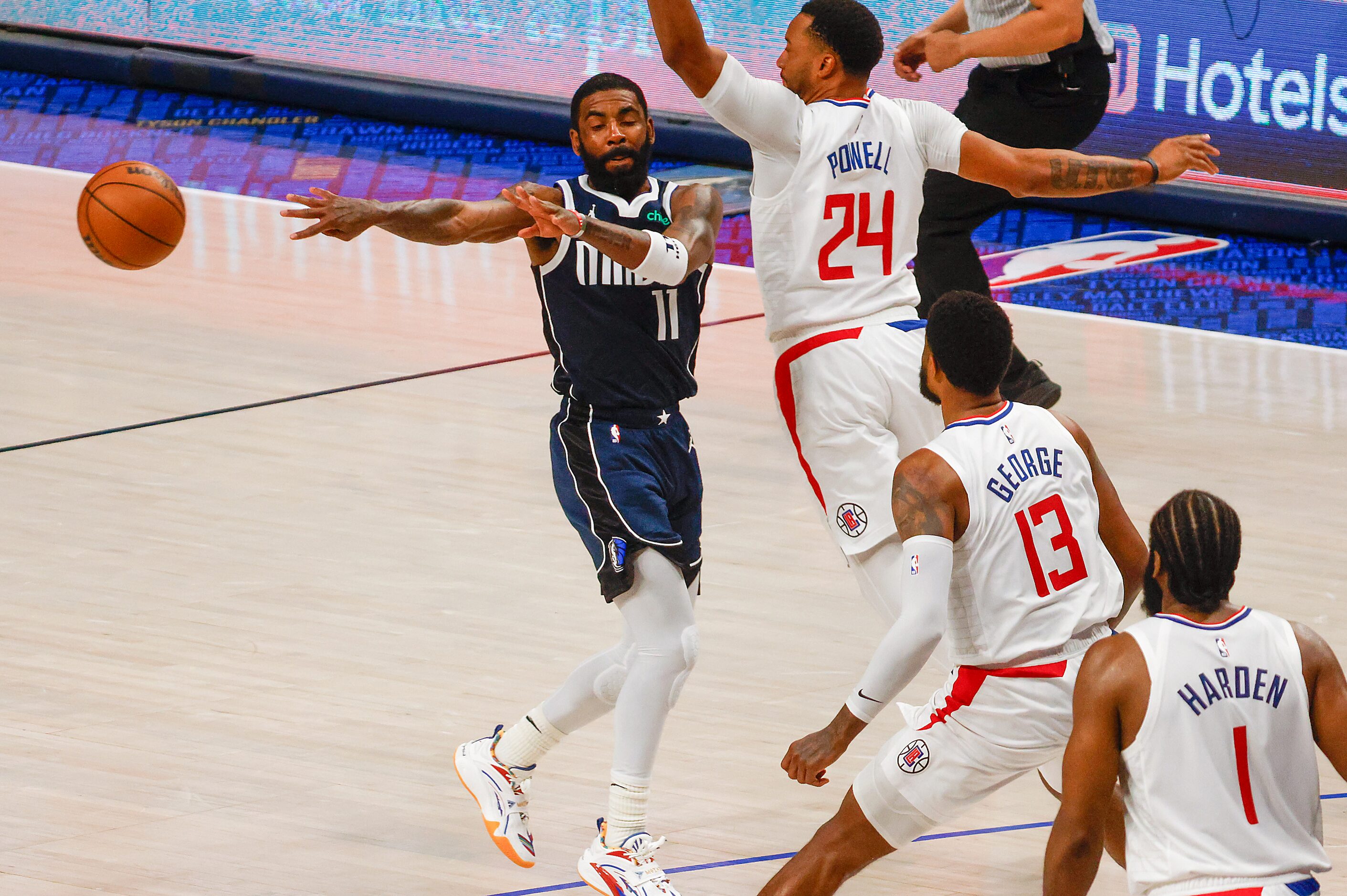 Dallas Mavericks guard Kyrie Irving (left) passes away the ball from LA Clippers guard...