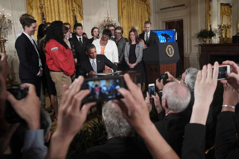 President Barack Obama, backed by student loan borrowers, signs an executive order aimed at...