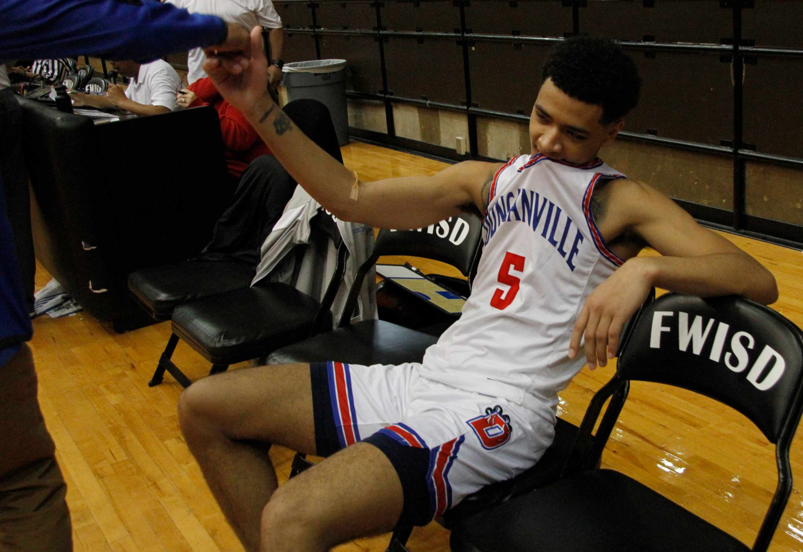 Duncanville guard Micah Peavy (5) takes in the moment as he receives congratulations from a...