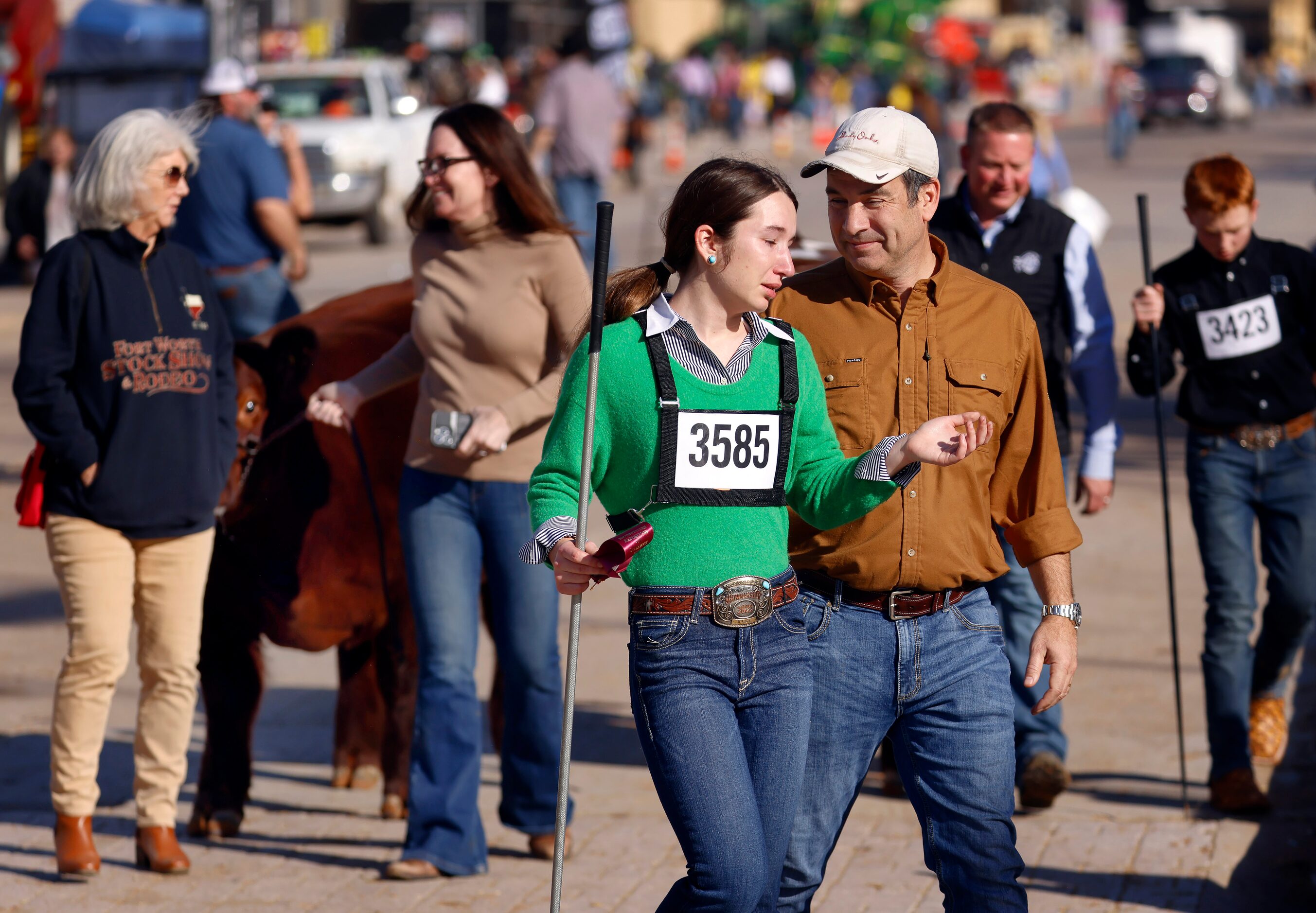 Mark Rollins of Fort Worth comforts his daughter Anna Rollins, 15, after she missed the top...