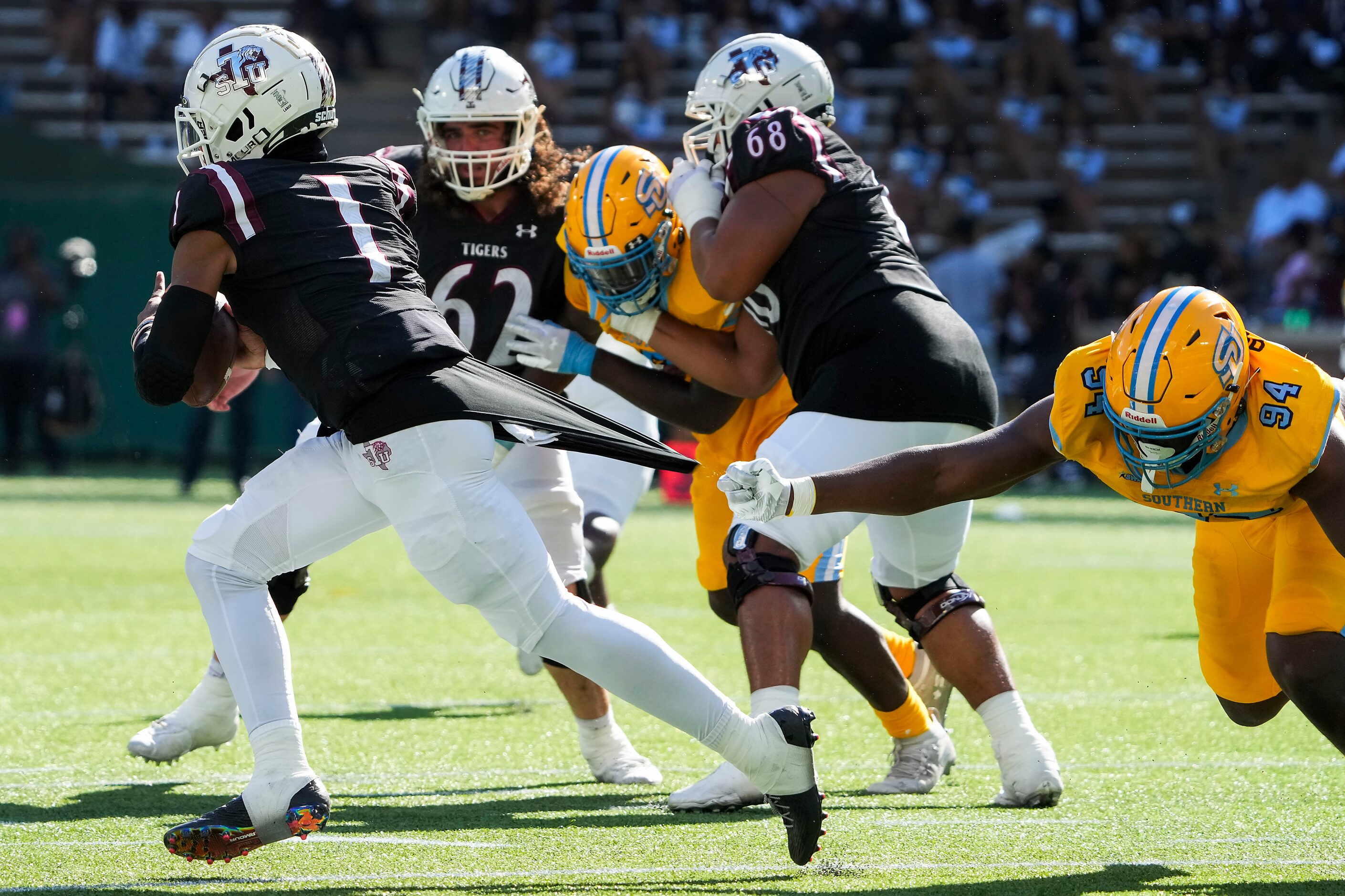 TSU quarterback Andrew Body (1) slips away from Southern  defensive lineman Camron Peterson...