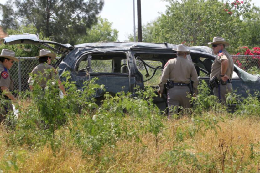 Texas Department of Public Safety troopers examine a van that was carrying 19 people when it...