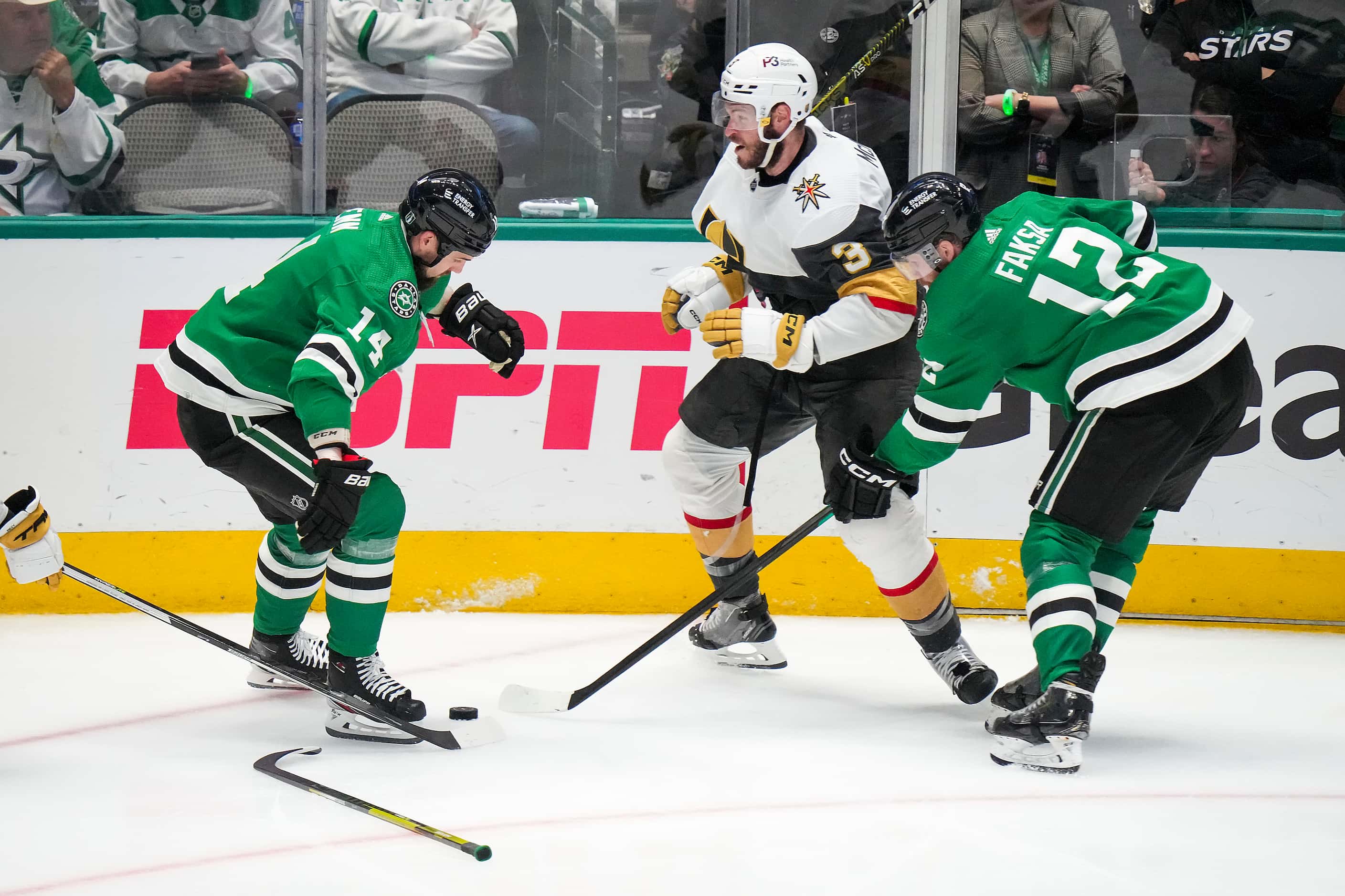 Dallas Stars left wing Jamie Benn (14) loses his stick as he fights for the puck with center...