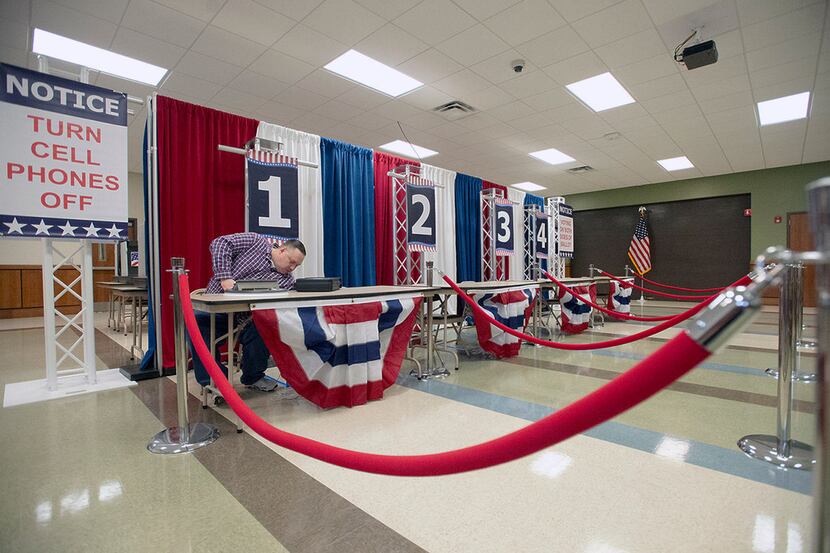 Nacogdoches County Elections Commissioner Todd Stallings sets up a check-in station inside...