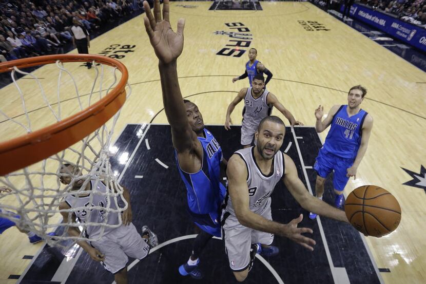 San Antonio Spurs' Tony Parker (9), of France, is defended by Dallas Mavericks' Samuel...