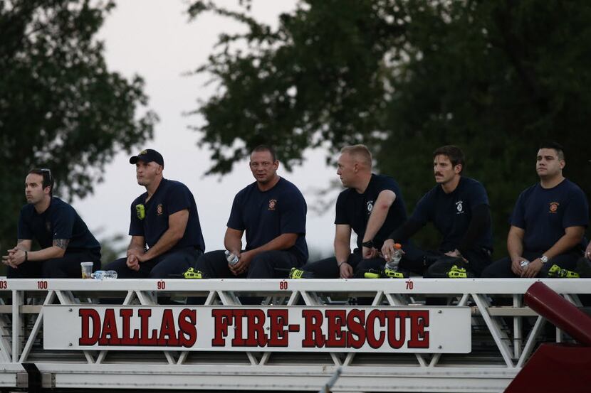 Members of Station 57 of the Dallas Fire Department watch from atop their truck before the...
