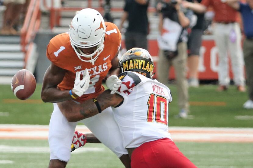 Texas Longhorns wide receiver John Burt (1) coughs up the ball after bing hit by Maryland...