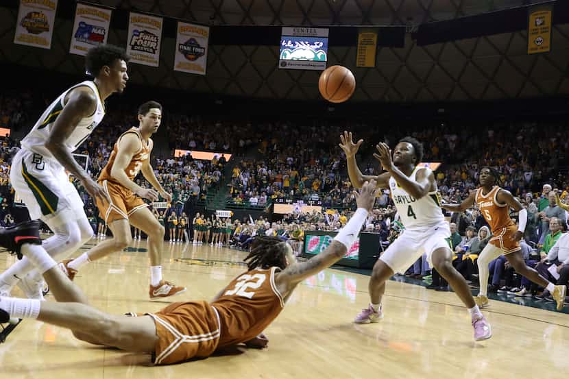 Baylor guard LJ Cryer (4) pulls in a loose ball over Texas forward Christian Bishop (32) in...