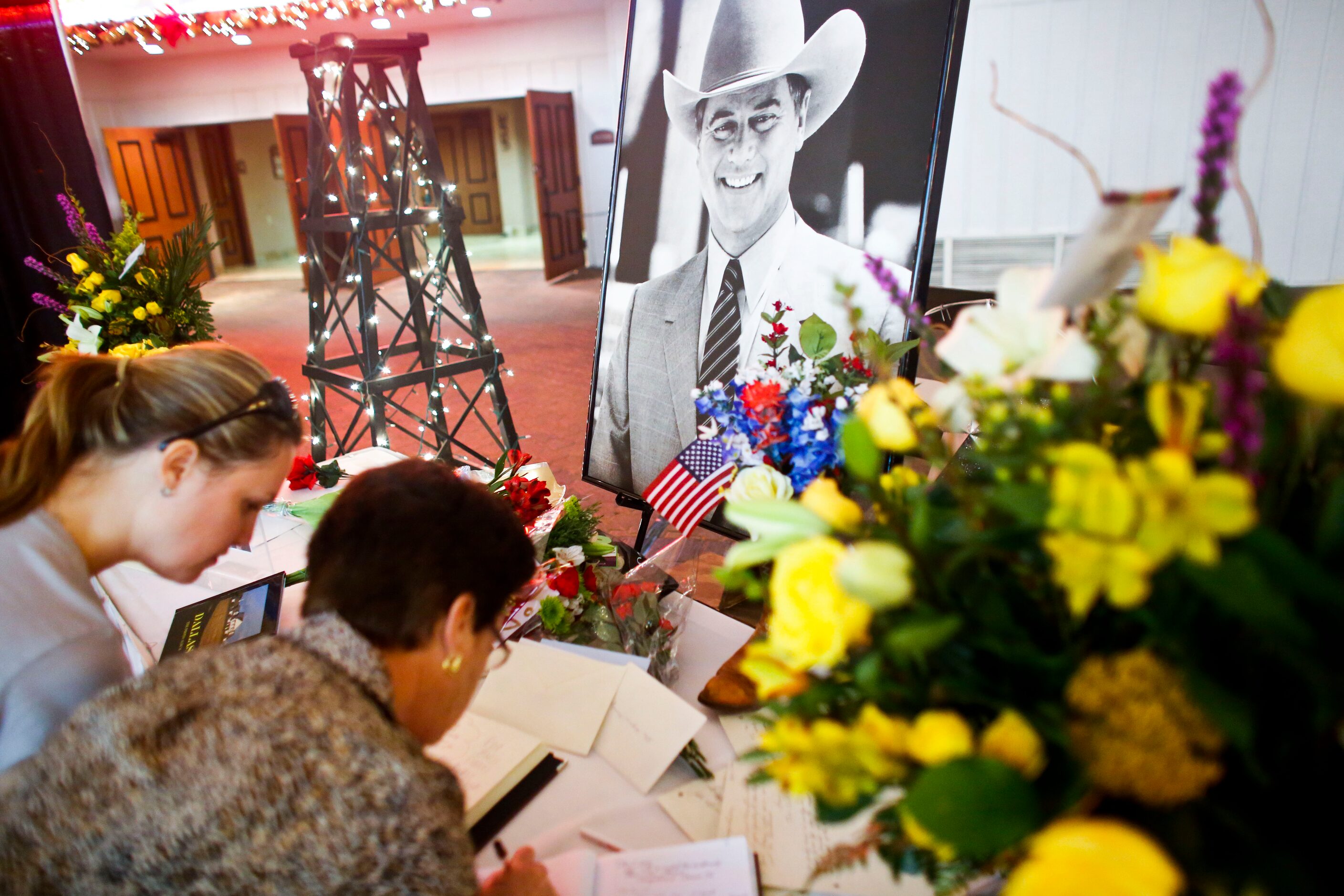 Carine Fazzani, left, and Anna Maria Padilha (cq) sign a book at a memorial service for...