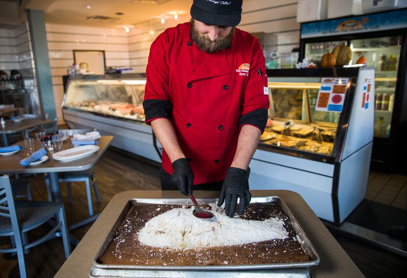 Chef and co-owner Ryan Oruch breaks into a baked Salt-Crusted Red Snapper dish at Sea Breeze...