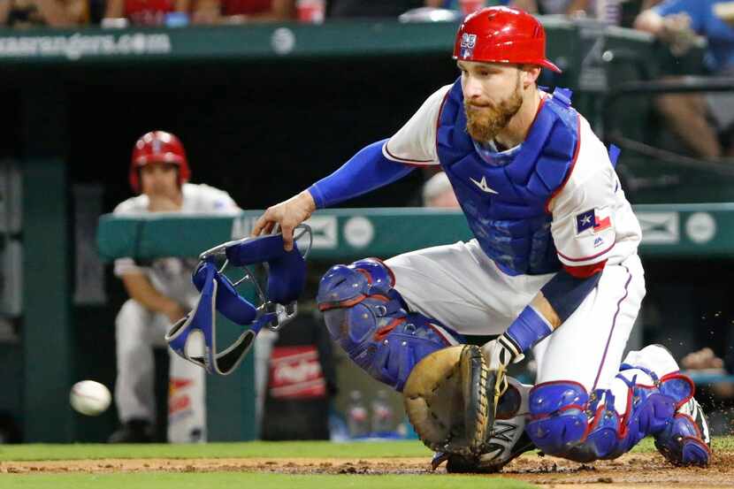 Texas Rangers catcher Jonathan Lucroy (25) blocks the throw as it comes in from the outfield...