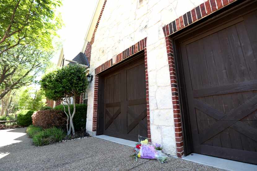 Flores yacen al pie del garaje en una casa en Nueces Drive, en Allen, en donde un joven de...