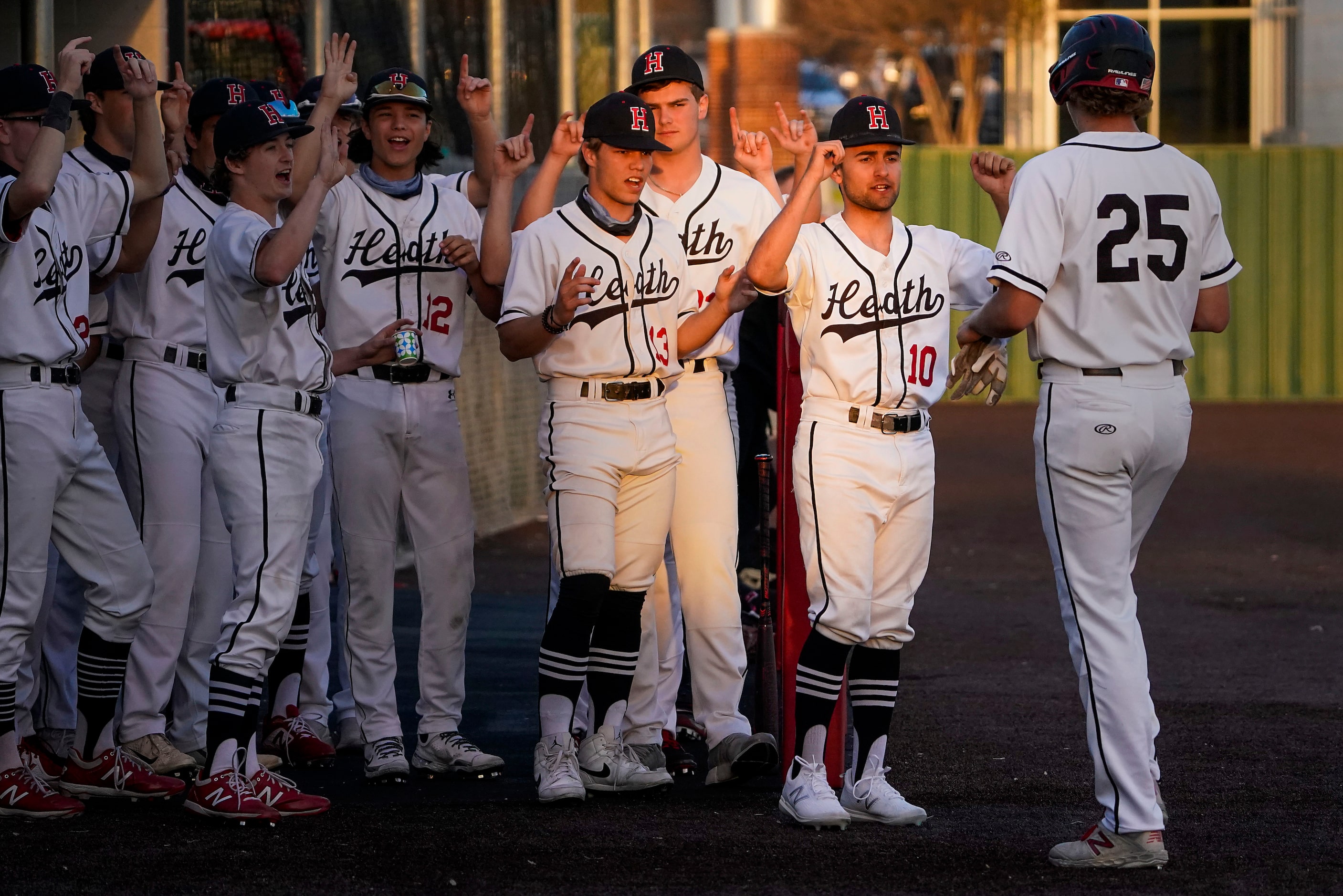 Rockwall-Heath players cheer first baseman Katson Mason (25) after he scored a run during a...