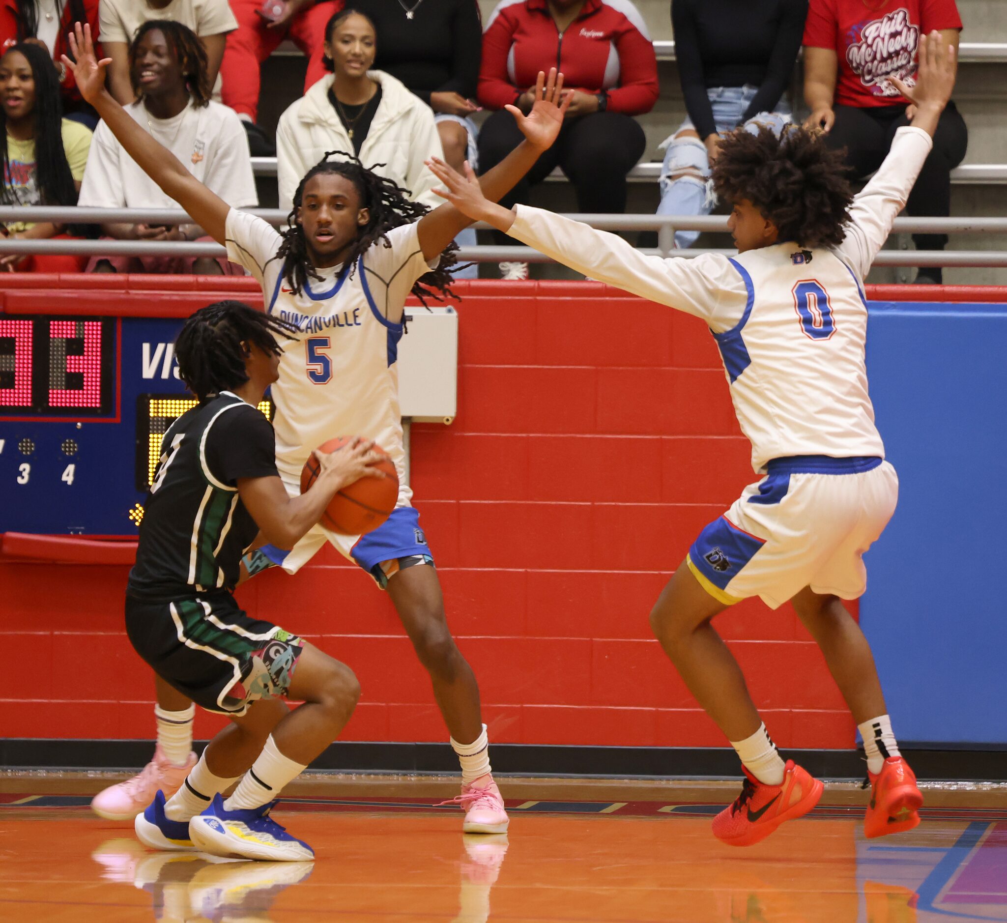 DeSoto guard Miles Pitt (0), left, looks to pass as he is defended by Duncanville guards...