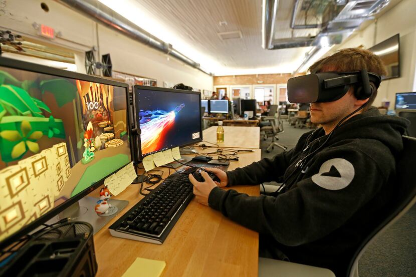Software engineer Anthony Fleshner works at his desk as he wears a VR gear at Playful Corp....