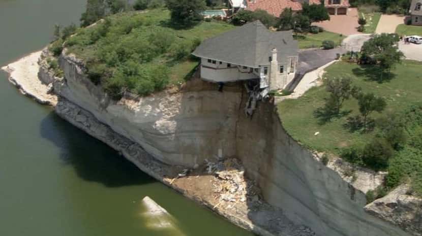 On Thursday, the house teetered on a cliff about 75 feet above Lake Whitney. 
