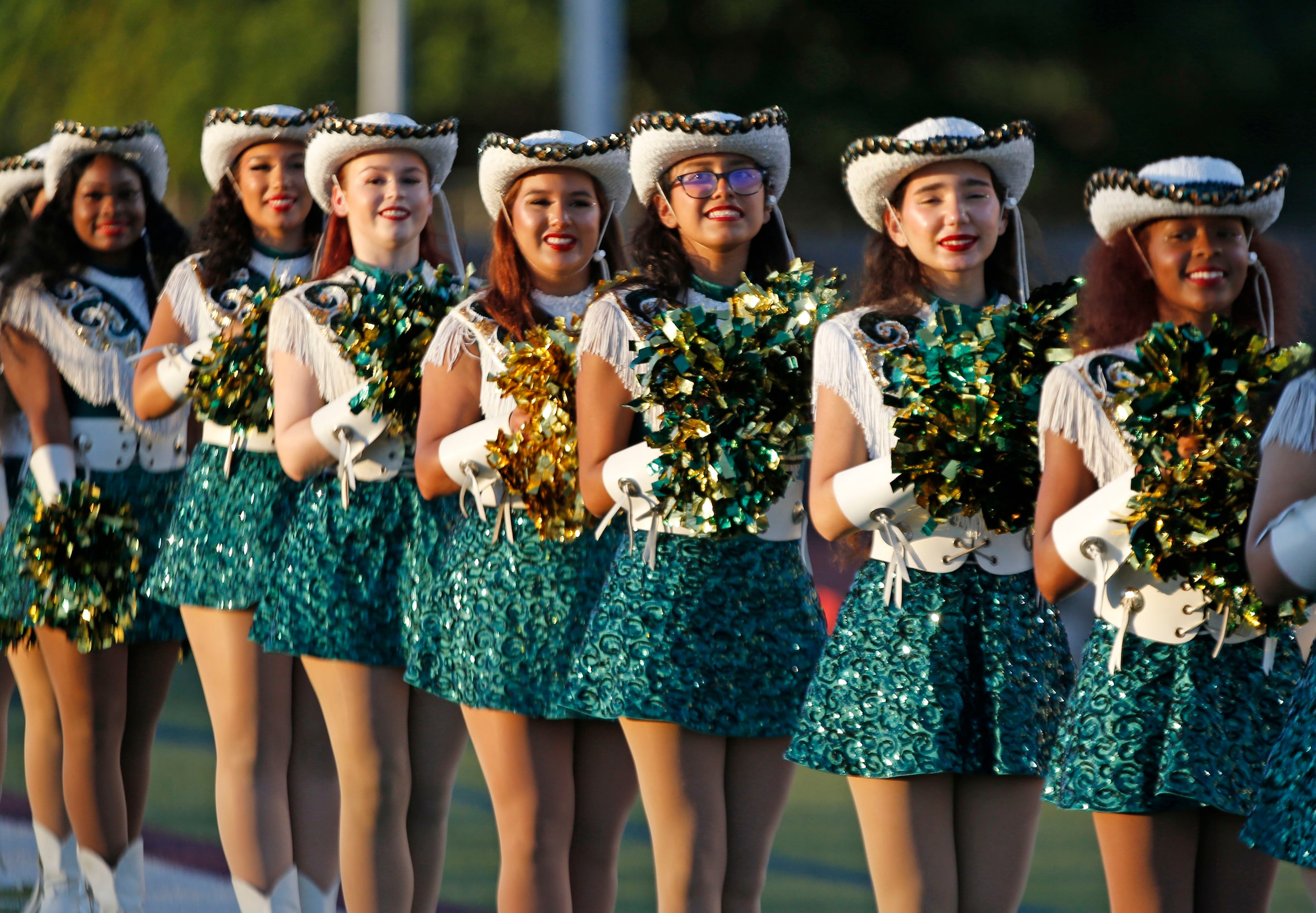 The Carrollton Newman Smith High drill team stands at attention in the late afternoon sun...