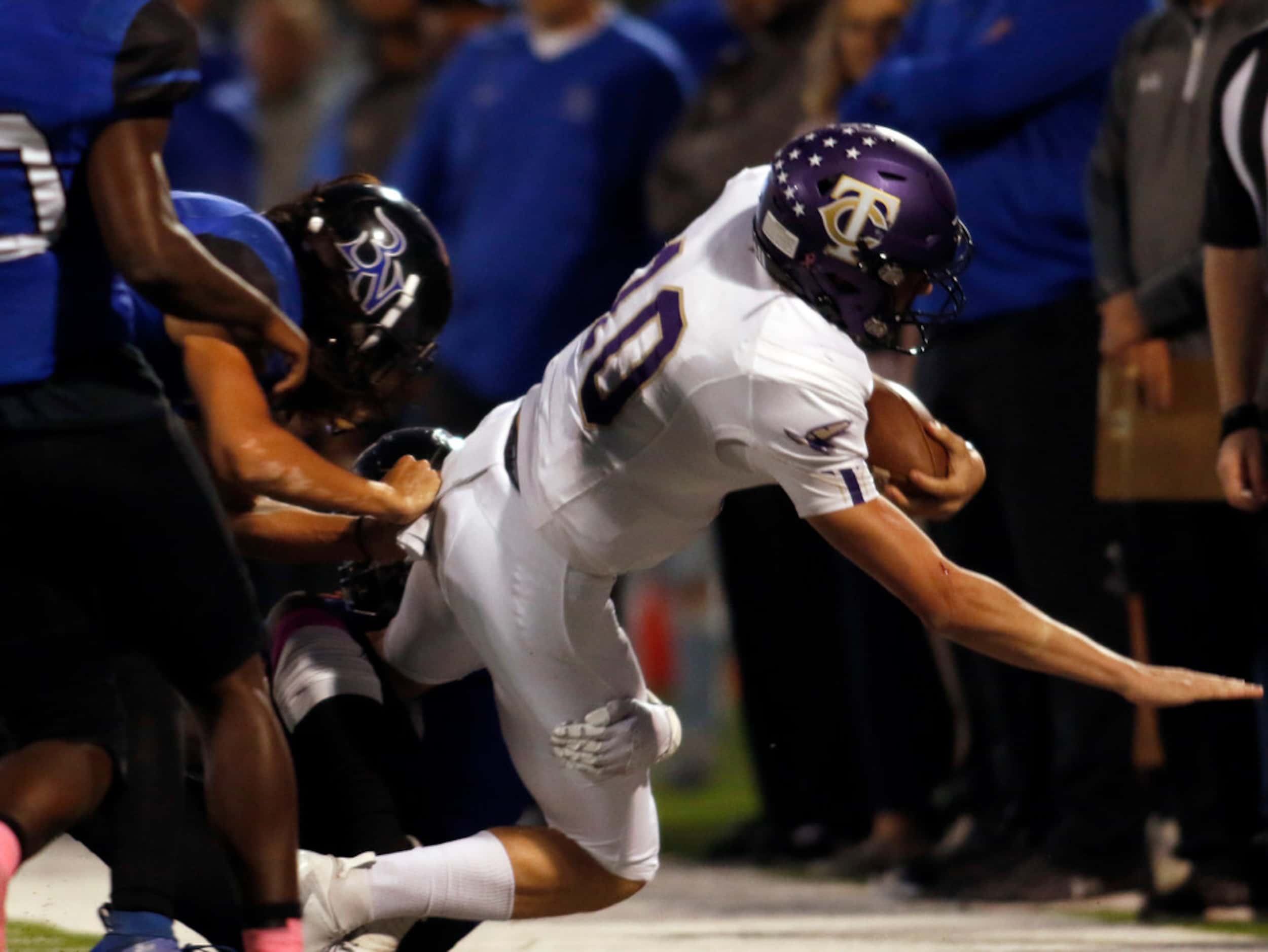 Keller Timber Creek quarterback Jason Akers (10) lunges for extra yardage as he is tackled...