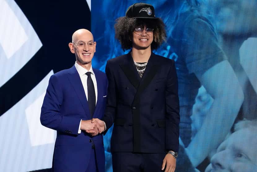 Anthony Black, right, poses with NBA Commissioner Adam Silver after being selected sixth...