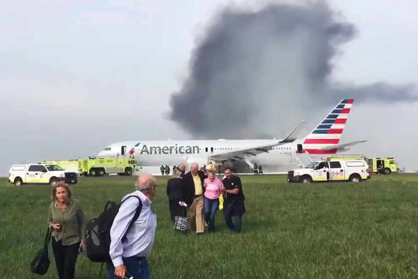 In this 2016 file photo, passengers walk away from a burning American Airlines jet that...