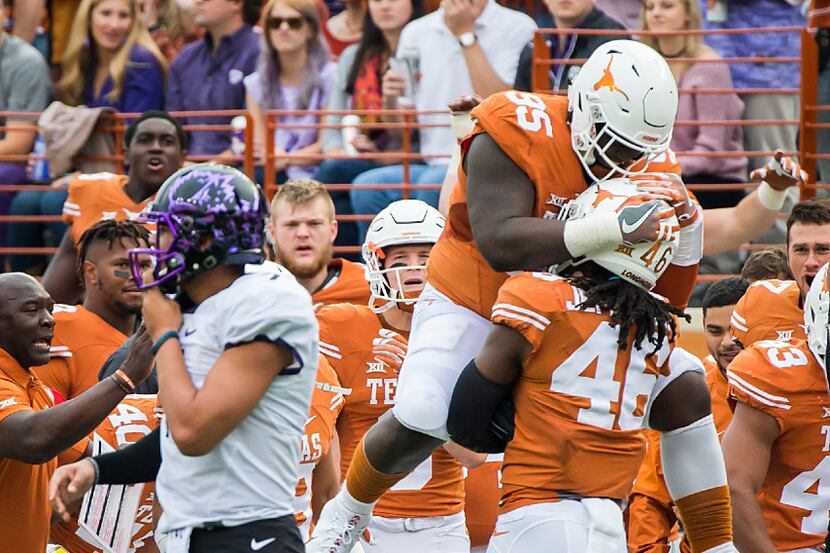 Texas linebacker Malik Jefferson (46) celebrates with defensive tackle Poona Ford (95) after...